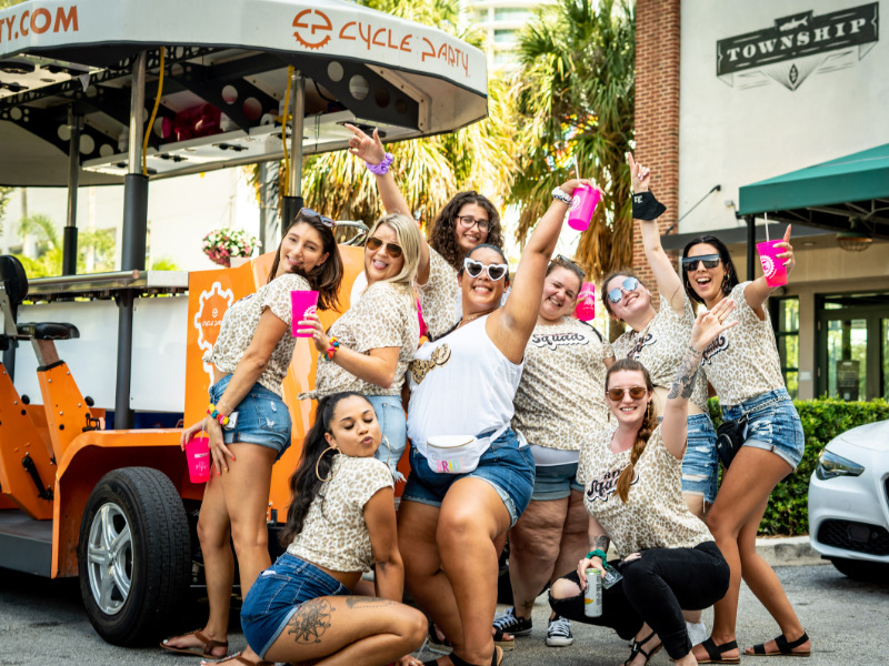 Bachelorette party posing in front of Cycle Party bike during the Las Olas Bar Crawl.